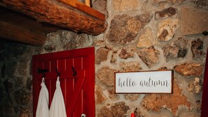A stone wall with a red door and a sign that reads "hello autumn." - The Stone Cabin; Off-the-grid experience with outhouse (Houston)