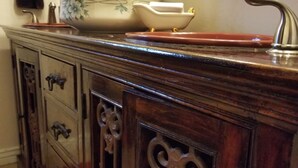 A wooden vanity with a large mirror, a sink, and decorative elements. - Garden-front studio  (Phoenix)