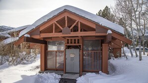 A wooden cabin with a snow-covered roof and a metal door. - Bright Cozy Snowcreek 1Bed/1Bath WIFI (Mammoth Lakes)