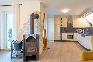 Une cuisine moderne avec un mur en pierre, des armoires en bois et une cuisinière intégrée.