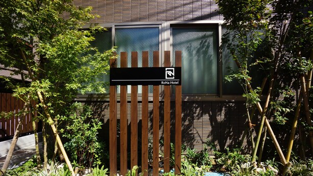 A wooden gate with a sign for RoNa Hotel. - Rona Hotel (Tokyo)