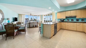 Uma cozinha espaçosa com uma ilha grande, armários de madeira e vista para o oceano.
