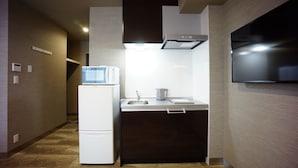 A compact kitchen with a built-in microwave, a sink, and a stove. - The South Hotel Tokyo (Tokyo)