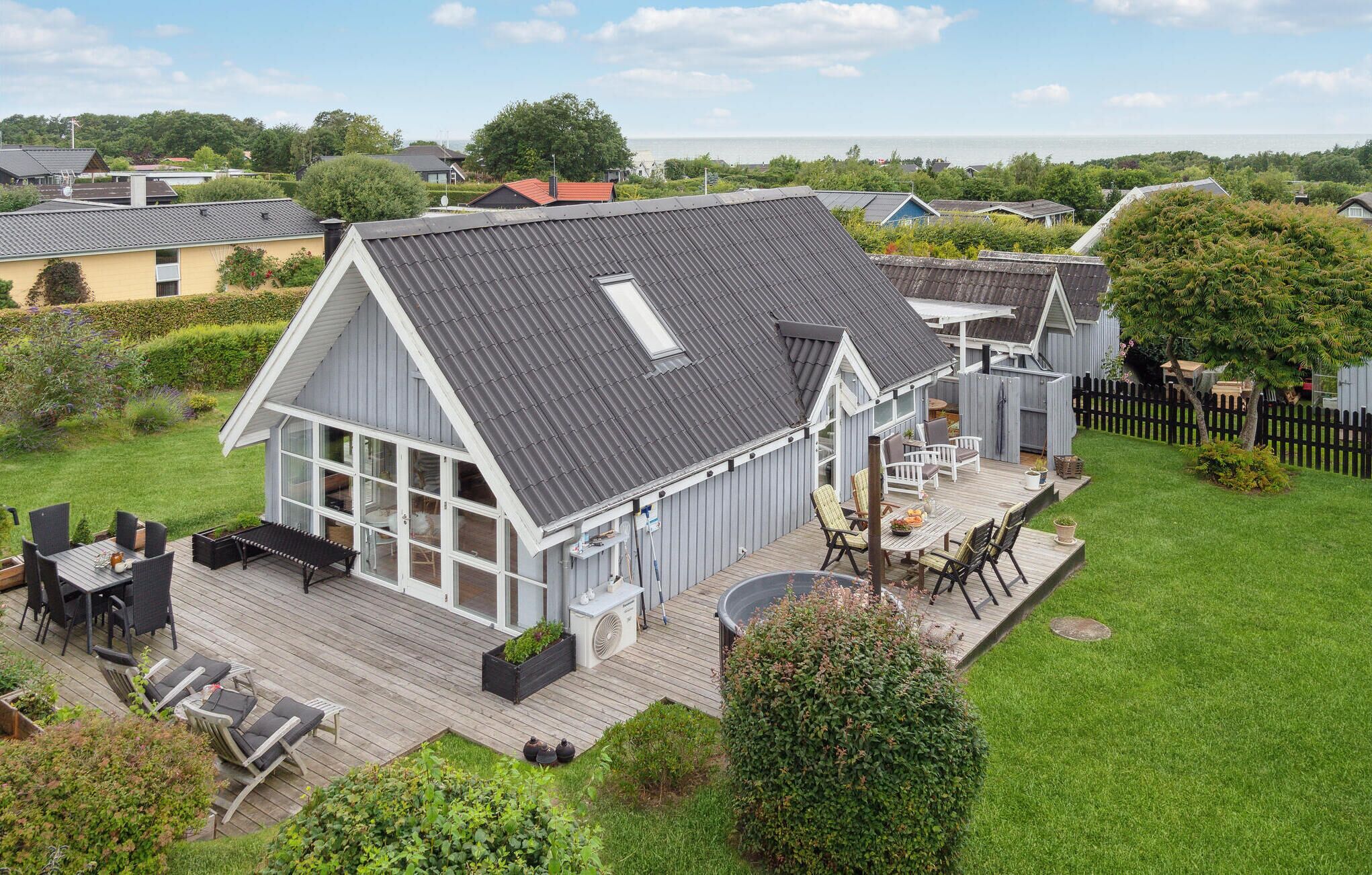 Ein großzügiges Haus mit einer geräumigen Terrasse, einer überdachten Veranda und Meerblick.