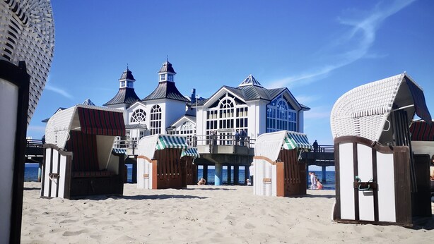 A beachside building with a large entrance, multiple windows, and a prominent tower.