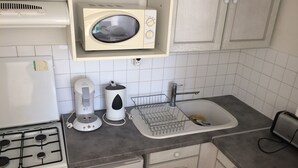 Keittiössä on liesi, mikroaaltouuni, kahvinkeitin, pesuallas ja leivänpaahdin.