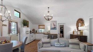 Una sala de estar acogedora con un sofá, una mesa de centro y un comedor con mesa y sillas.
