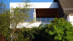 Un bâtiment moderne avec une façade blanche et une fenêtre à persiennes en bois.