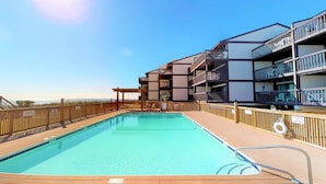 A swimming pool with wooden deck and metal railings, surrounded by a wooden fence. - Best Ocean View in Carolina Beach.. (Carolina Beach)