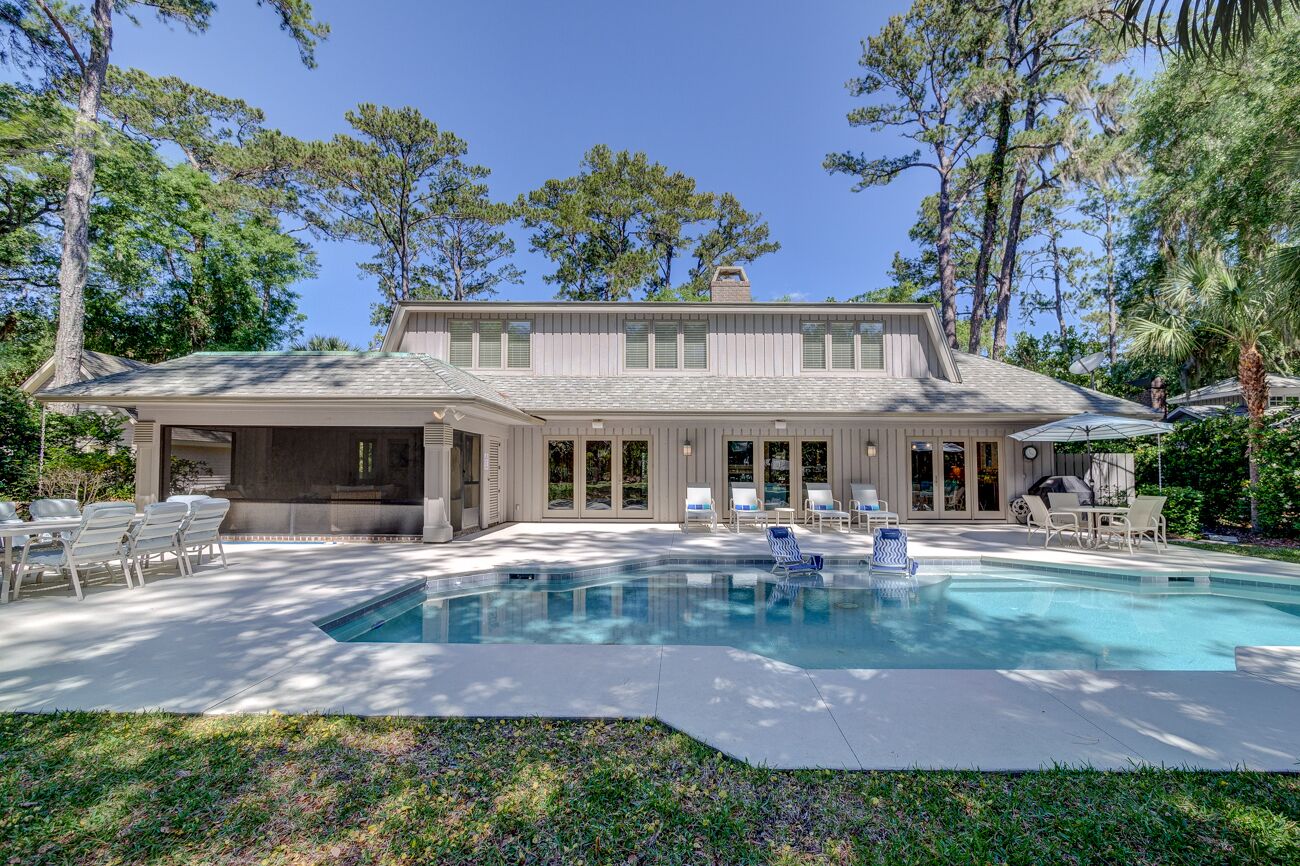 Une maison à deux étages dotée d’une piscine, d’un espace extérieur aménagé et d’un patio couvert.