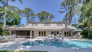 Une maison à deux étages dotée d’une piscine, d’un espace extérieur aménagé et d’un patio couvert.
