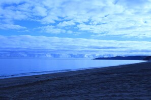 Uma praia com céu claro e águas calmas.