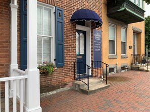 A brick building with a blue door and a sign indicating it is The Anderson House, offering bed and breakfast. - The Amberson House Bed & Breakfast (Waynesboro)