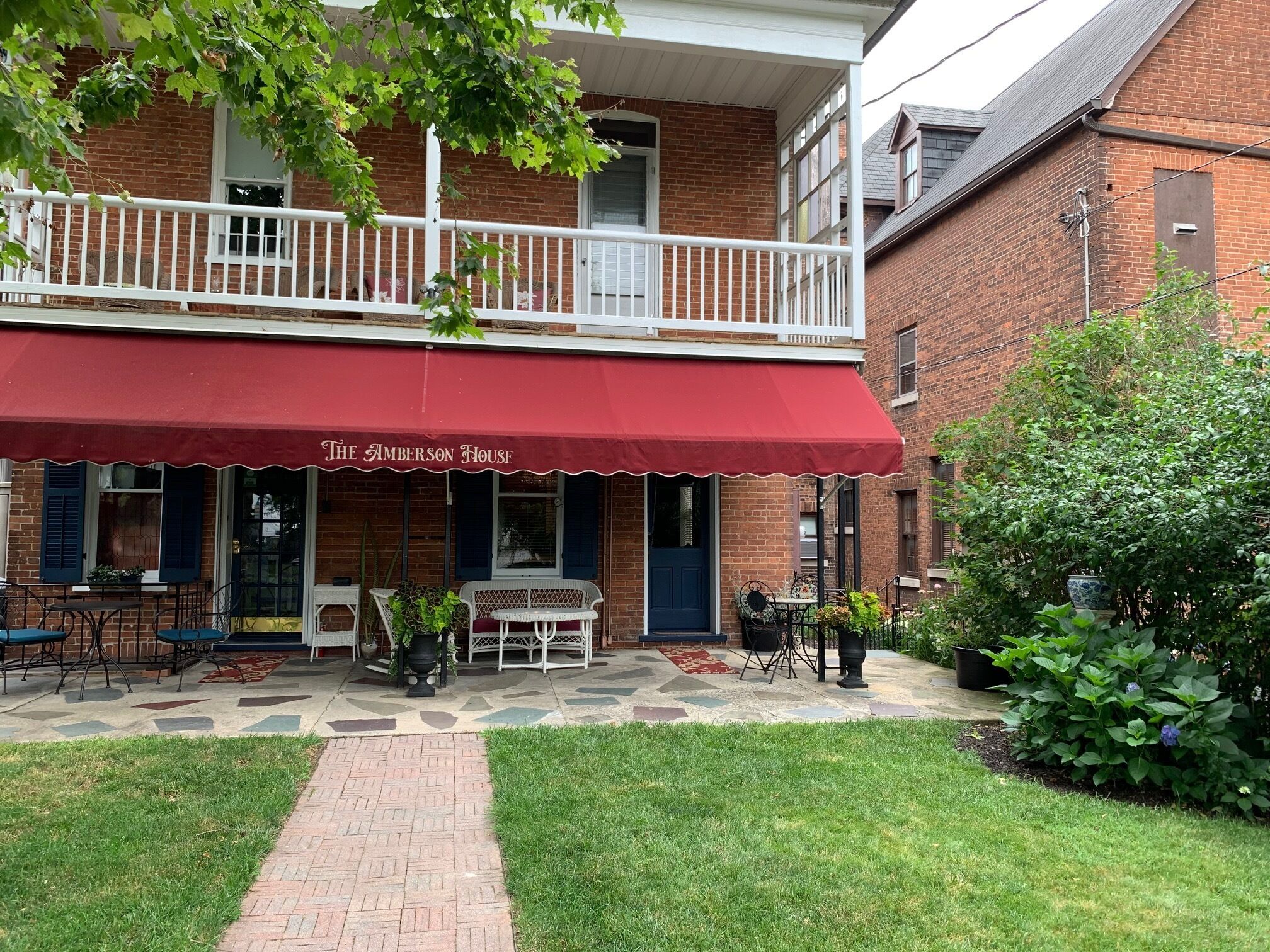 A brick building with a red awning labeled "The Amberson House."