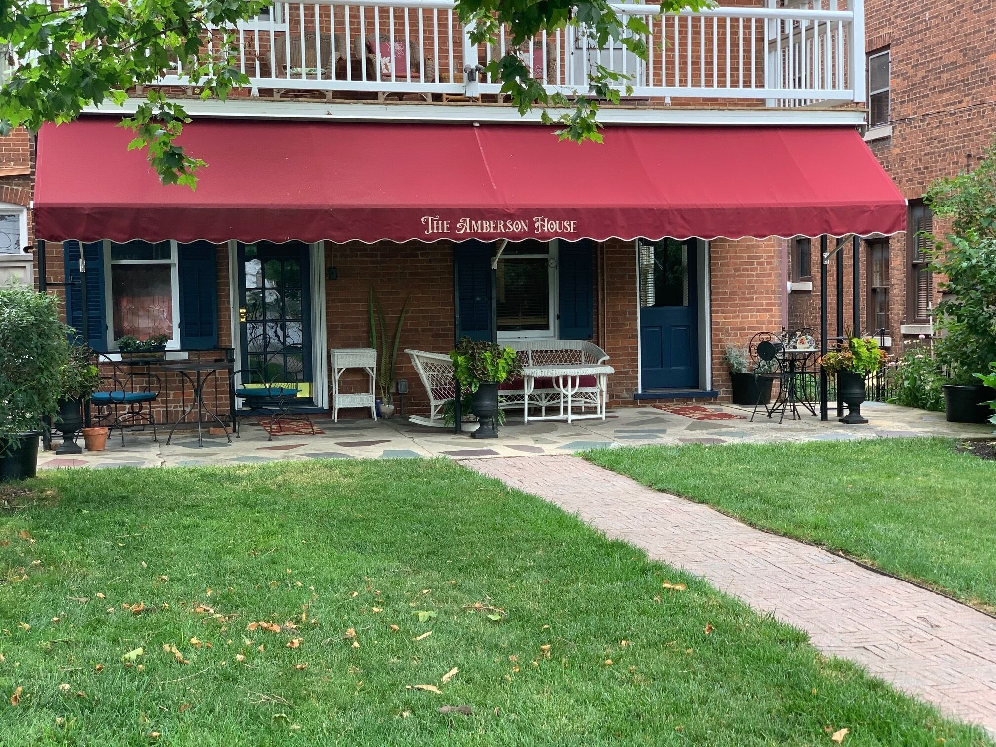 A brick building with a red awning labeled "The Amberson House."