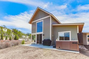 Een modern herenhuis met twee verdiepingen, een groot raam, terras en een jacuzzi.