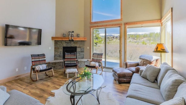 A spacious living room with a fireplace, comfortable seating, and large windows offering a view.