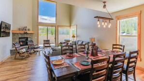 A spacious dining area with a large table, multiple chairs, and a fireplace.