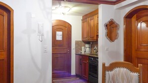 A kitchen with wooden cabinets, a coffee maker, and an oven. - Lovely apartment for 4 people with WIFI and TV (Zermatt)