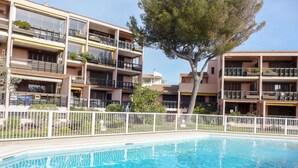 A multi-story hotel with balconies, a swimming pool, and a white fence. - Beautiful apartment for 4 people with pool, WIFI, A/C, TV and terrace (Fréjus)
