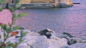 A historic stone fortress by the sea with a prominent tower, surrounded by rocky terrain. - Wide Apartment with Terrace in City Center (Napoli)