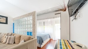 Une chambre moderne avec un lit, un canapé et une grande fenêtre avec des rideaux.