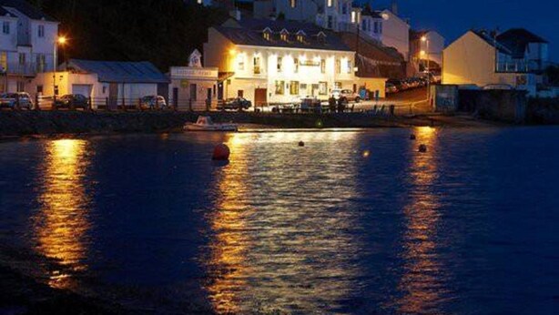 A waterfront hotel with a large building reflecting on the water, a dock with boats, and a calm evening setting. - Riverside retreat by Brunel’s Bridge, balcony view, off‑road parking, EV charger (Plymouth)