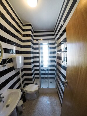 Een bad/douchecombinatie, een haardroger, een bidet, handdoeken