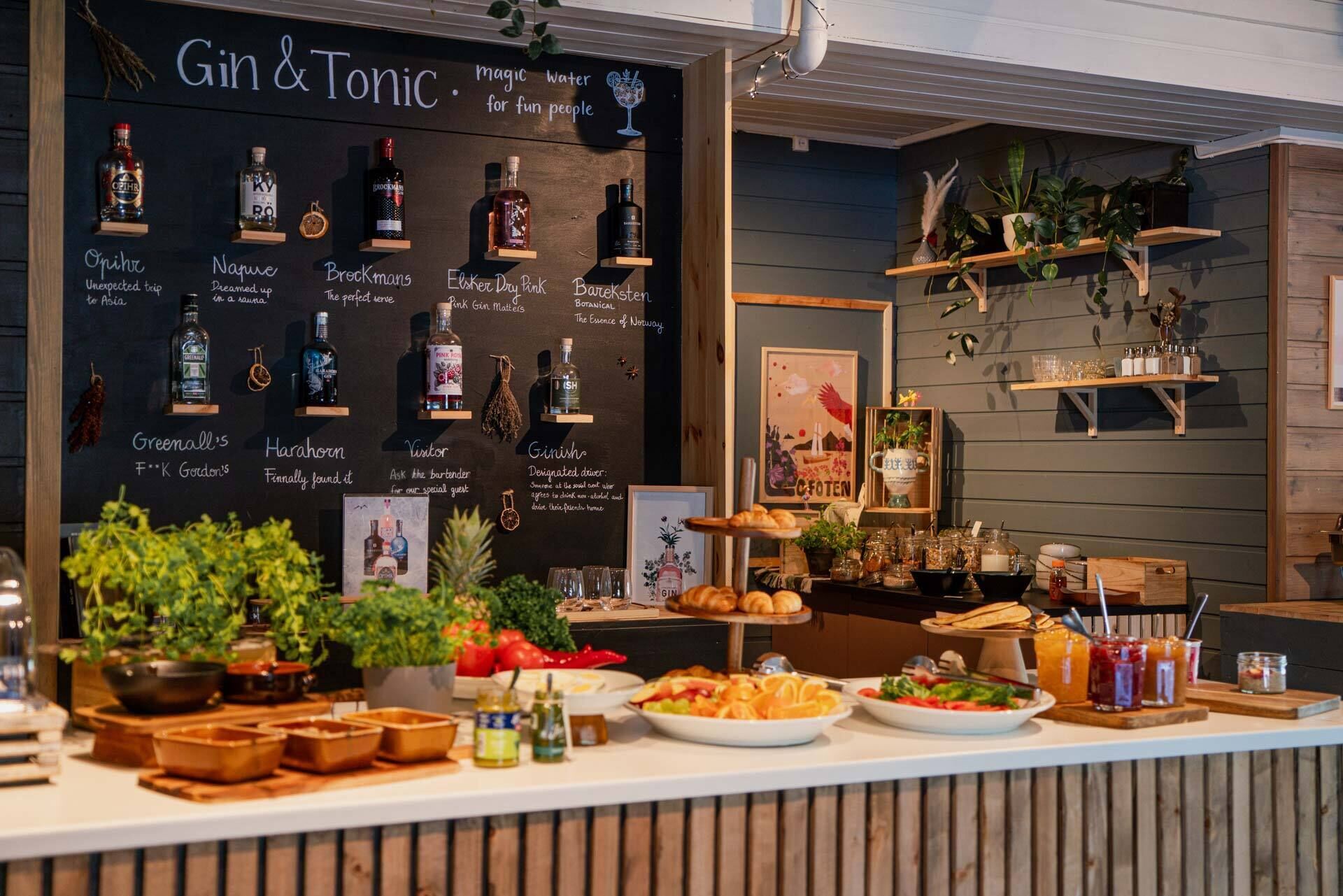 Un espace bar où une variété de bouteilles de gin et de tonic sont exposées sur des étagères, un tableau affichant le menu avec des descriptions, et un comptoir proposant des plats et des boissons.