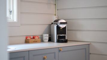 A kitchen with a coffee machine, a wine rack, and a cabinet.