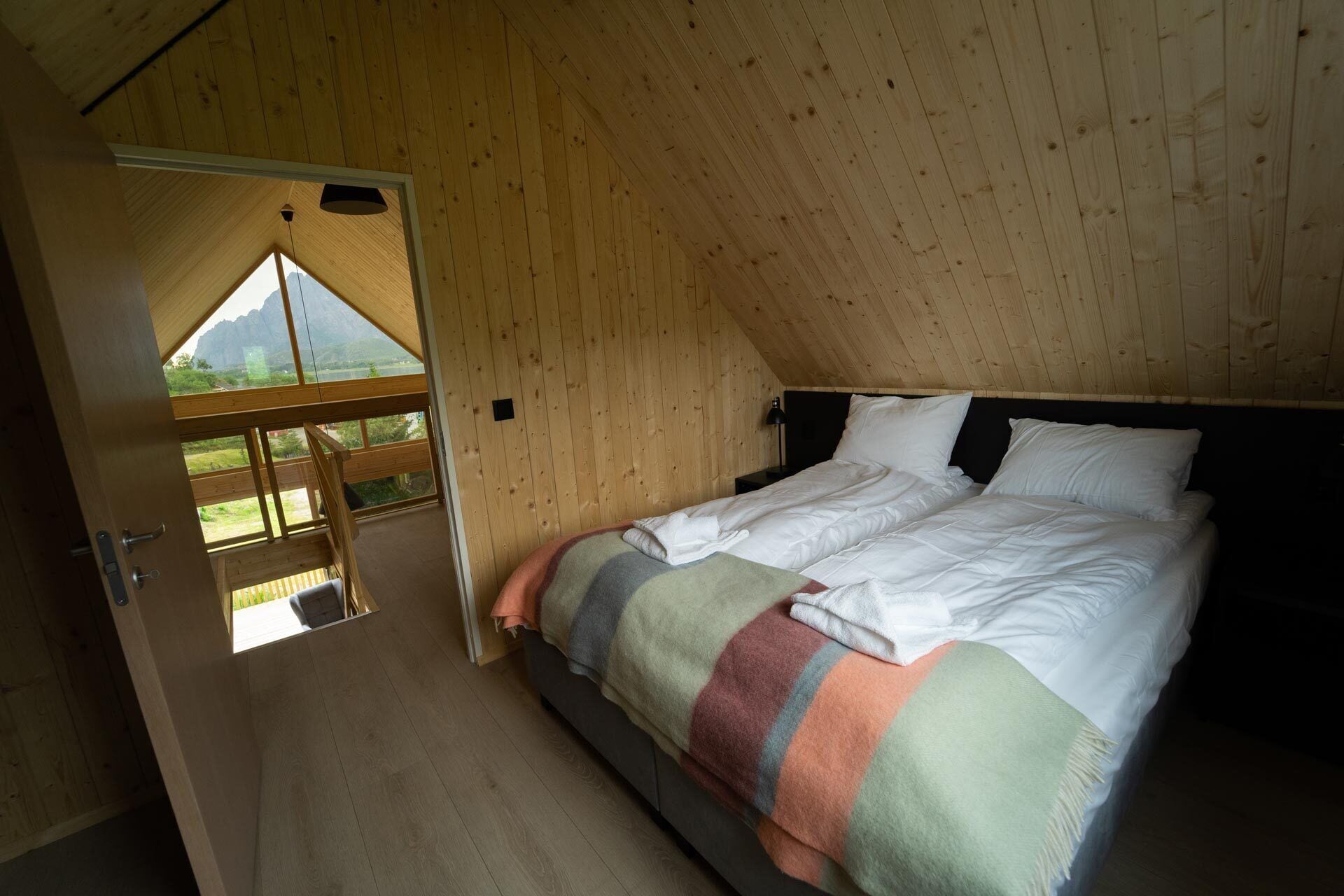 Une chambre avec un plafond en bois et une grande fenêtre.