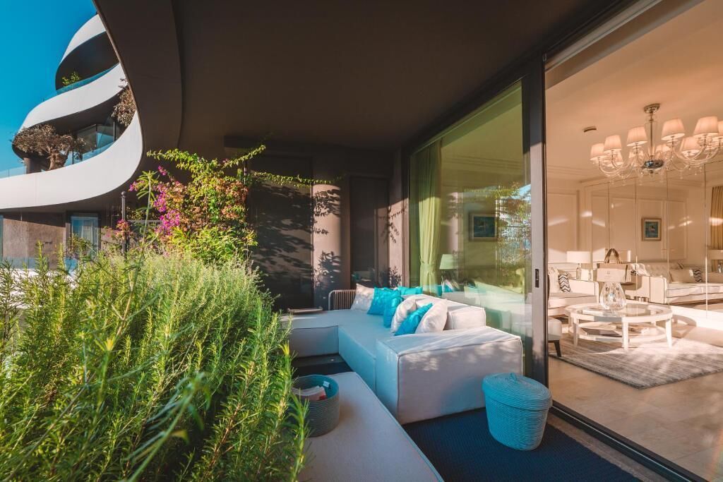 A modern living room with a curved wall, a sofa set, and a glass partition.