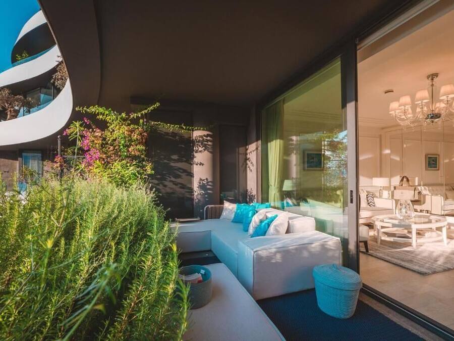 A modern living room with a curved wall, a sofa set, and a glass partition.