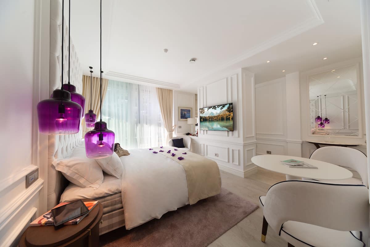Une chambre d’hôtel moderne dotée d’un grand lit, d’une télévision, d’un coin repas et d’une salle de bain.