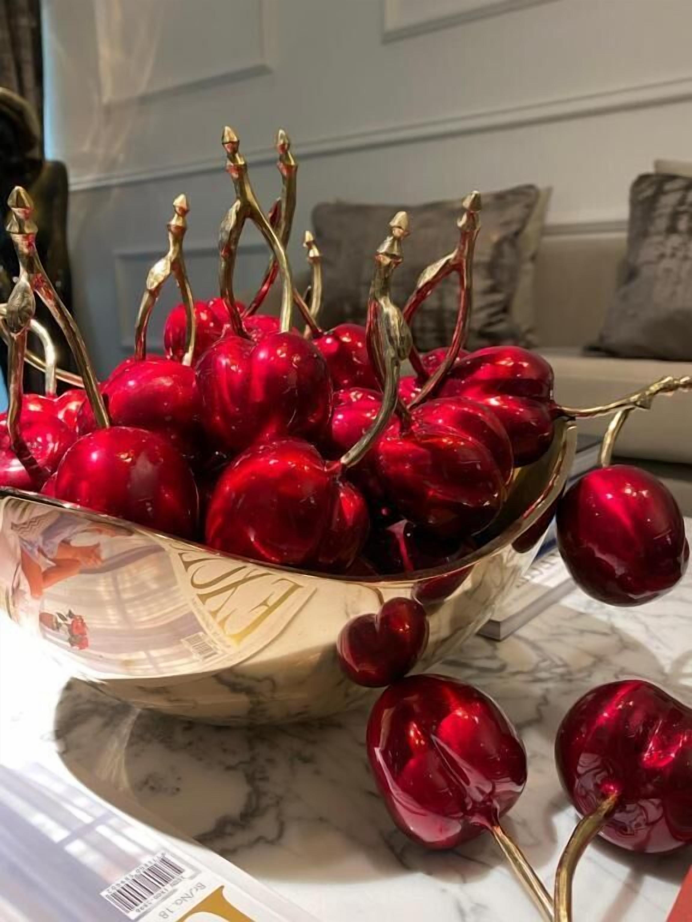 A bowl of cherries on a marble surface.