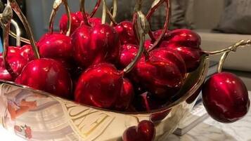 A bowl of cherries on a marble surface.