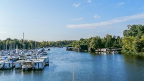 A marina with numerous boats docked along the water, surrounded by trees and a clear sky. - Lovely apartment in Rechlin with lake view (Rechlin)