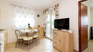Une cuisine compacte avec un coin repas, un téléviseur et un meuble en bois.