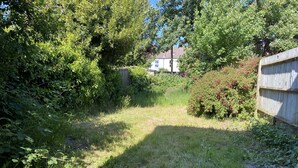 A backyard with a stone pathway leading to a house, surrounded by dense greenery and a wooden fence. - Shirley House Self Catering Guest House, 5 min Drive to Cruise Ship Terminals and City Centre (Southampton)