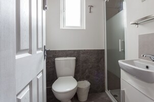 A bathroom with a toilet, a sink, and a shower.