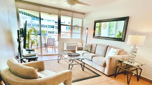 A living room with a sofa, armchair, coffee table, and a lamp.