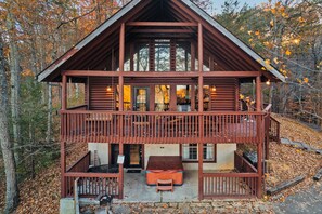Sit on the balcony and take in the serene forest views from this cozy cabin's upper level.