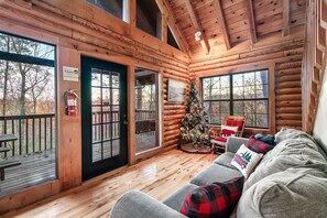 Relax in a cozy cabin with a spacious living area, perfect for unwinding or socializing, and enjoy stunning views of the surrounding forest.