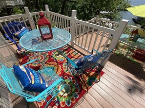 A deck with a round table, chairs, and a lantern. - 4 Bedroom Lakeview home next to Margaritaville (Osage Beach)