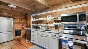 Une cuisine moderne dotée d’appareils électroménagers en acier inoxydable, de murs en bois et d’un four encastré.