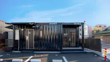 A modern, compact building with two entrances, each marked with a unique code.