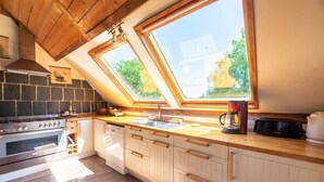 A kitchen with a skylight, a stove, a sink, and wooden cabinets. - Quaint Holiday Home in Ferce (Fercé)
