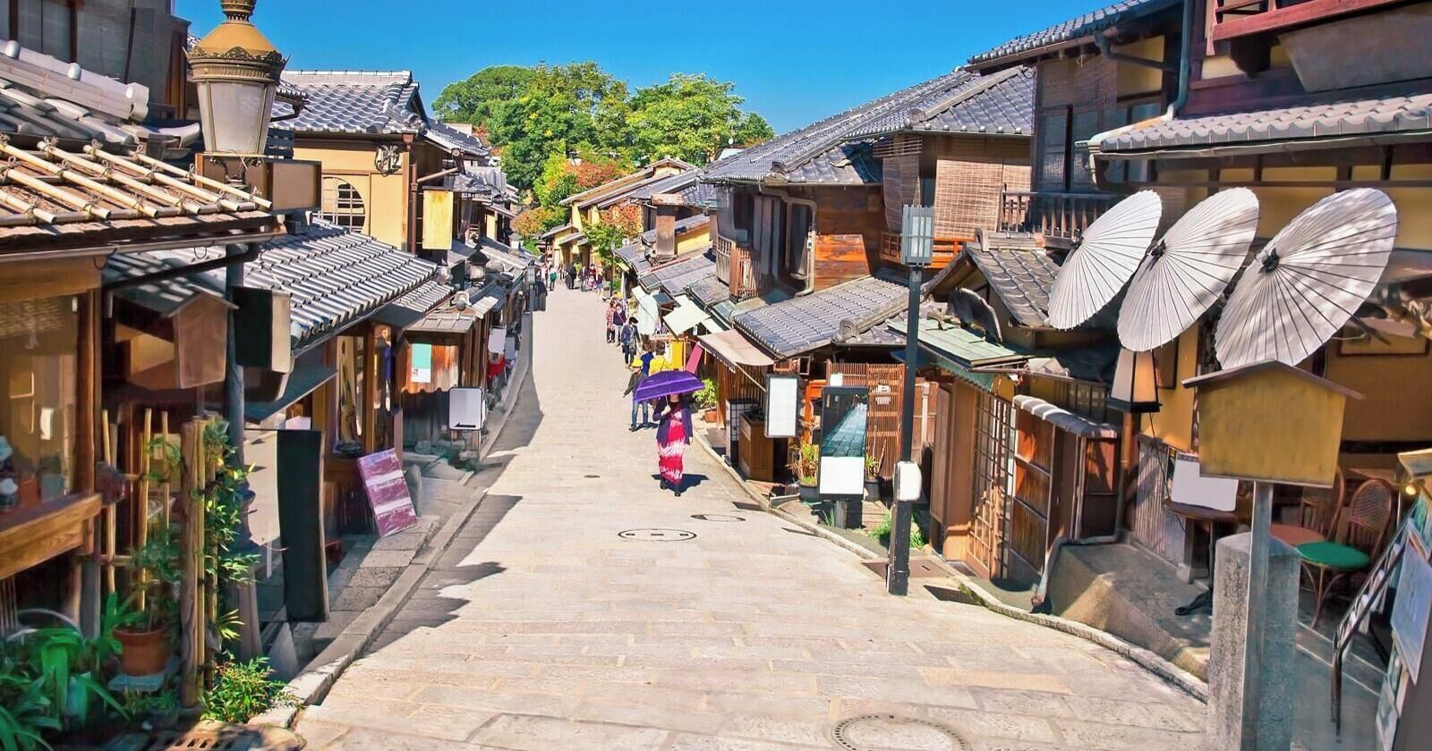 A narrow street lined with traditional buildings, some with large fans on the exterior.