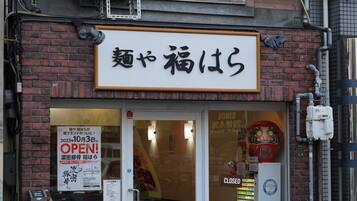 A storefront with a sign in Japanese, a closed sign, and a menu board outside.