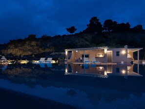 A modern house with a pool, lounge chairs, and a patio area. - Villa in Peloponnese With Pool (Ermionida)